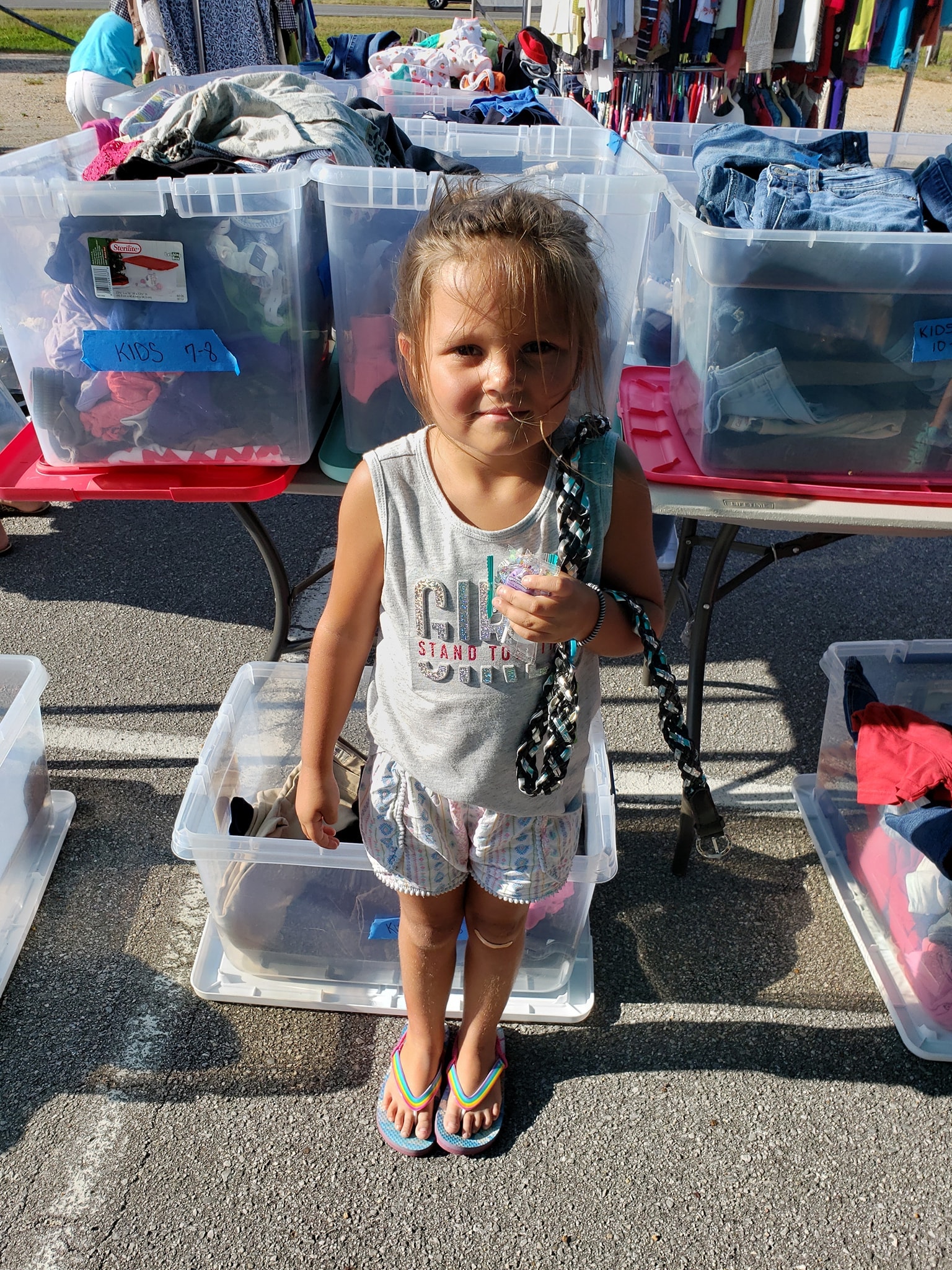 Young girl at outdoor clothing sale
