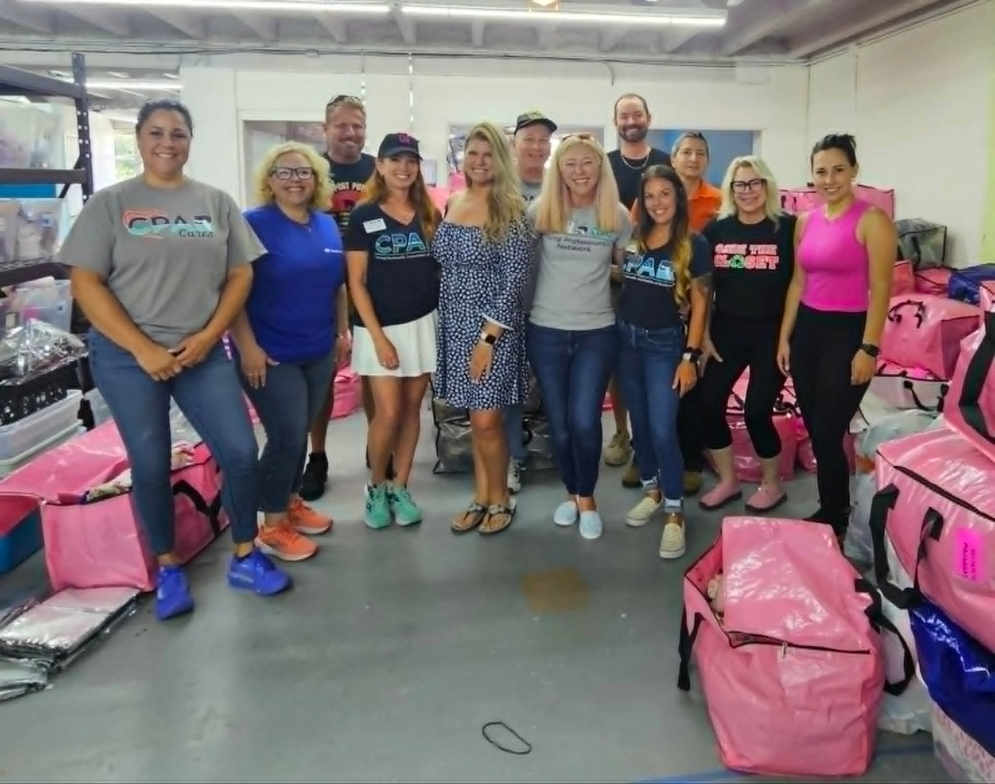 Group posing in warehouse with pink bins