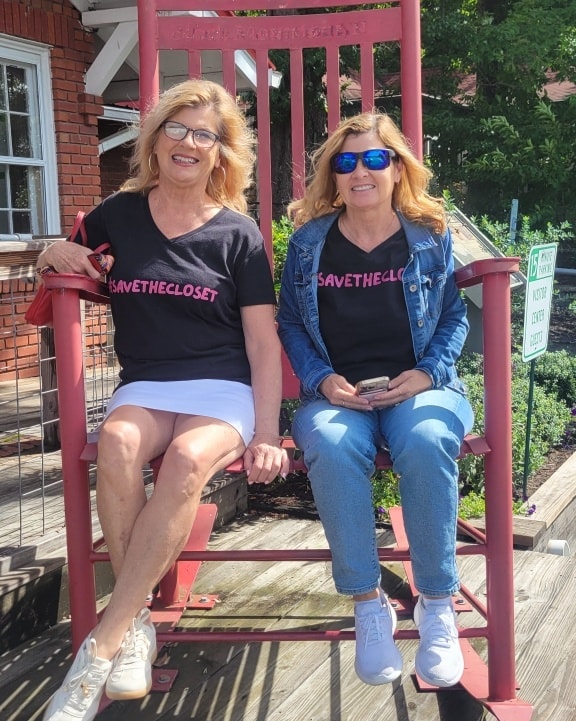 Two women sitting on red porch swing