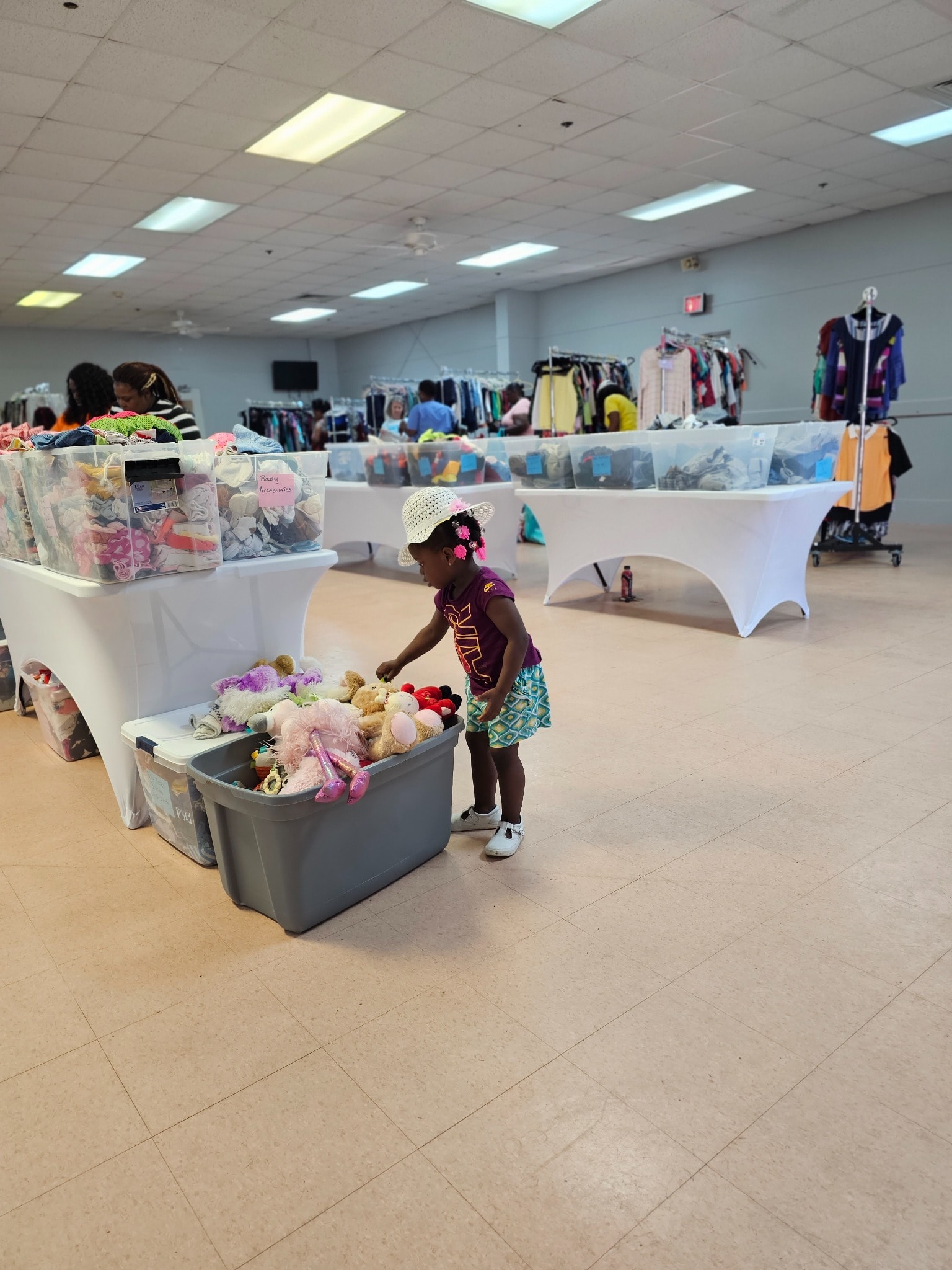 Indoor community giveaway with child browsing toys