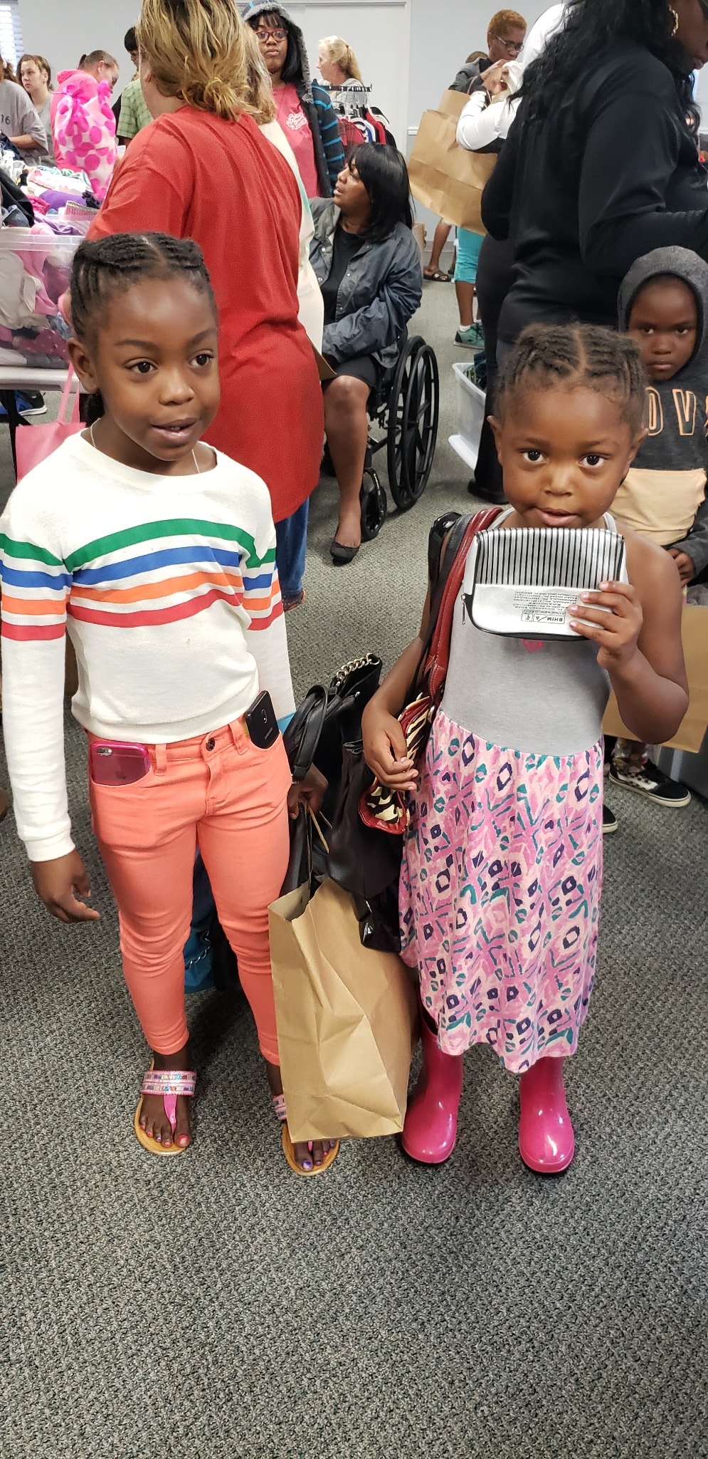 Two young girls at community clothing giveaway