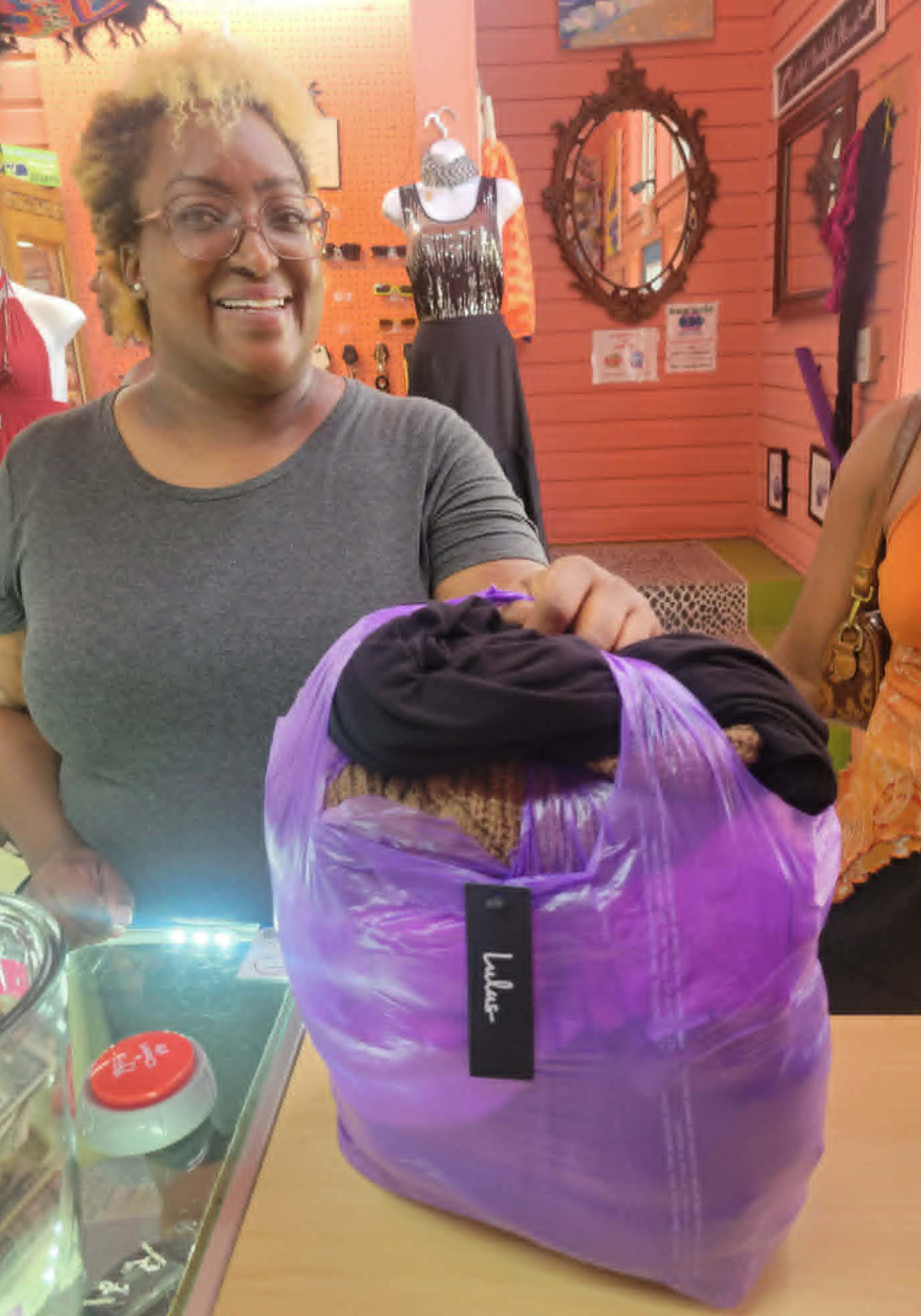 Smiling shopper with a full purple bag at the Bargain Attic